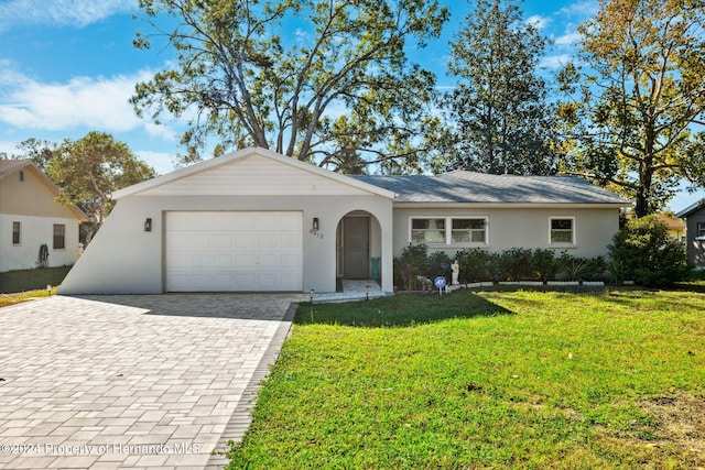 ranch-style house with a garage and a front lawn