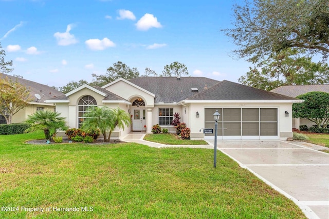 ranch-style home with a garage and a front yard