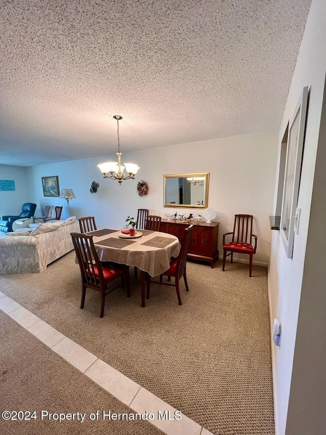 carpeted dining room with a textured ceiling and a notable chandelier