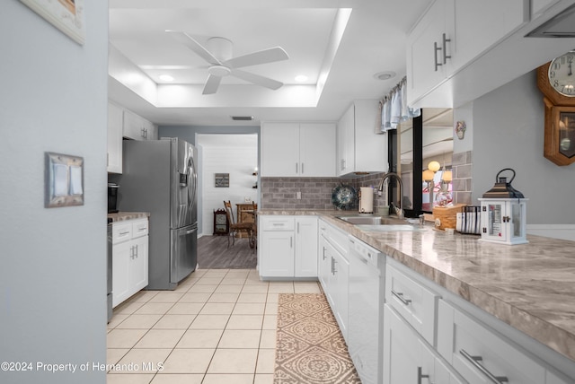 kitchen with white cabinets, a raised ceiling, sink, stainless steel refrigerator with ice dispenser, and ceiling fan