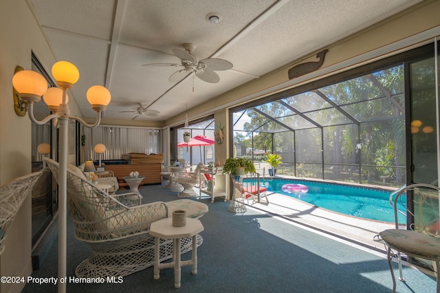 view of swimming pool with a patio area, a jacuzzi, ceiling fan, and glass enclosure