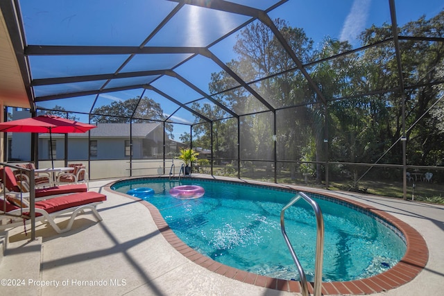 view of pool with a lanai and a patio