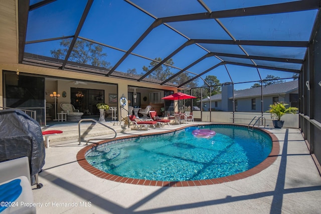 view of swimming pool with a patio area and glass enclosure