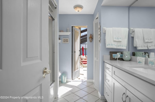 bathroom with tile patterned flooring, vanity, and an enclosed shower