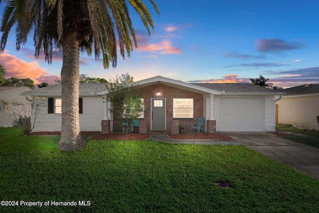 ranch-style house with a yard and a garage