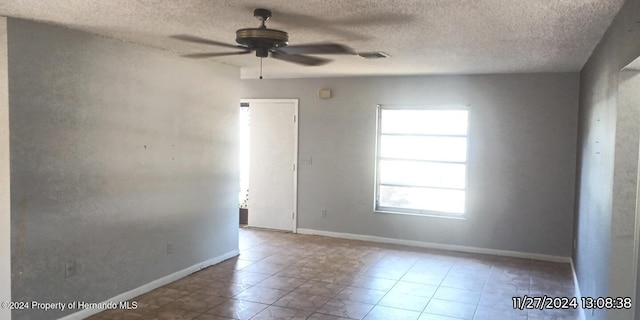 spare room with ceiling fan and a textured ceiling