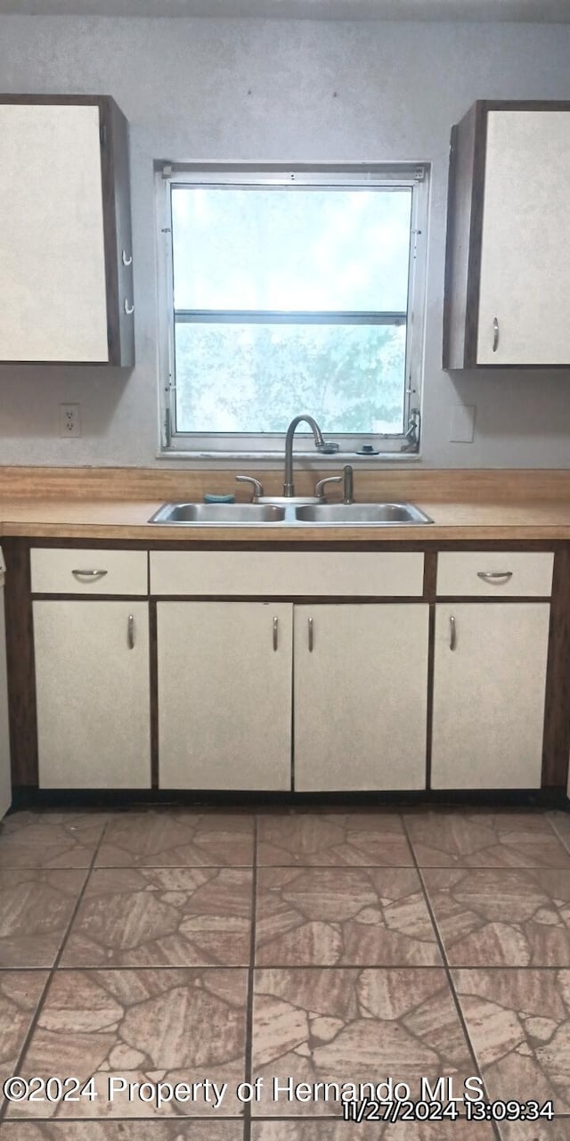 kitchen with white cabinets, plenty of natural light, and sink