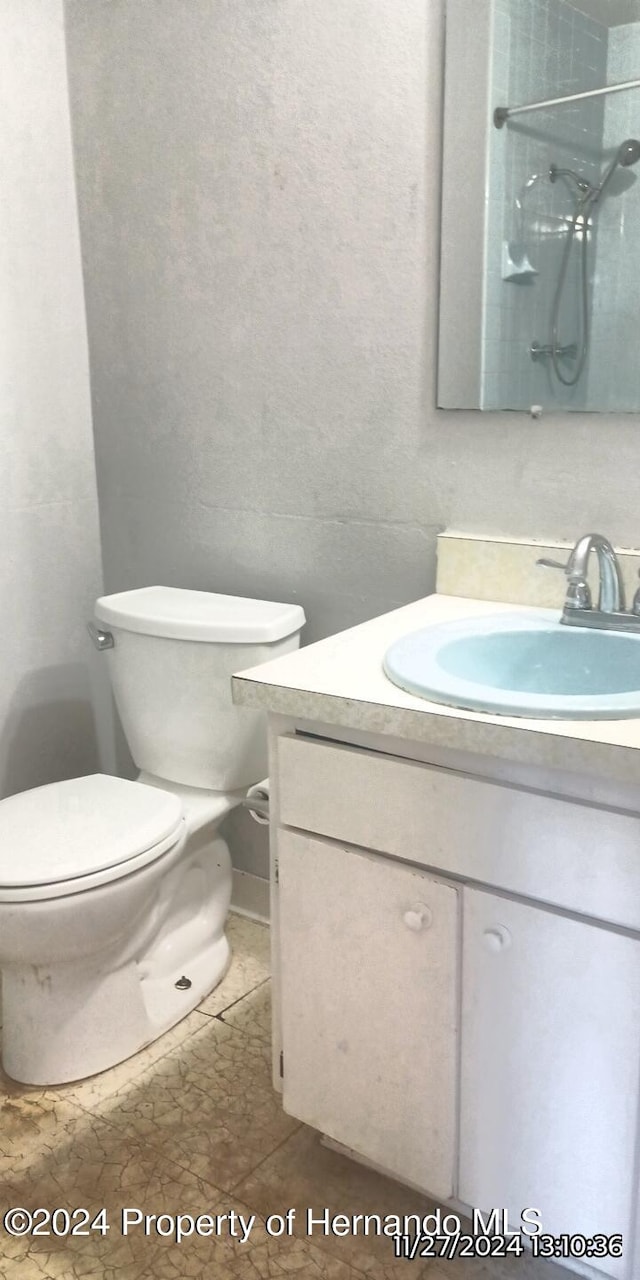 bathroom featuring a shower, tile patterned floors, vanity, and toilet