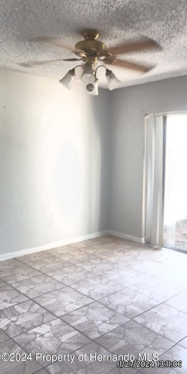 spare room with ceiling fan and a textured ceiling