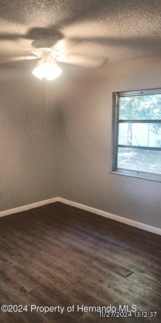 unfurnished room featuring a textured ceiling, dark hardwood / wood-style flooring, and ceiling fan