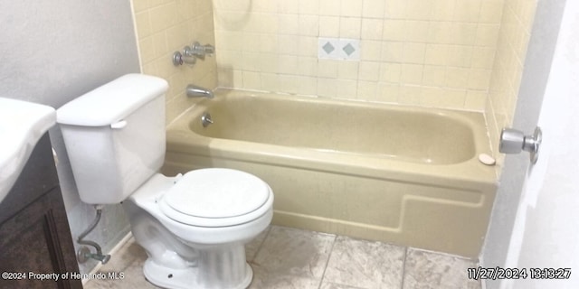 bathroom featuring toilet and tiled shower / bath