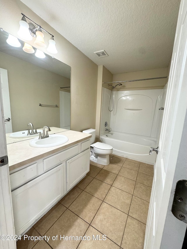 full bathroom featuring vanity, a textured ceiling, bathing tub / shower combination, tile patterned flooring, and toilet