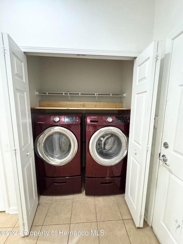 laundry room featuring separate washer and dryer and light tile patterned floors