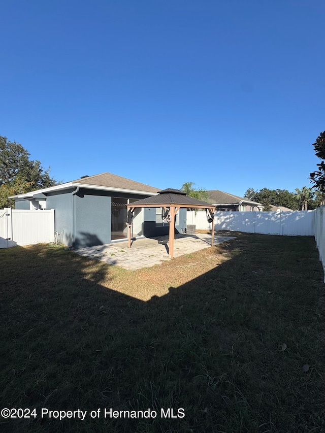 rear view of property featuring a gazebo, a patio area, and a yard