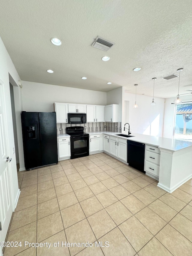 kitchen with pendant lighting, black appliances, white cabinets, sink, and kitchen peninsula