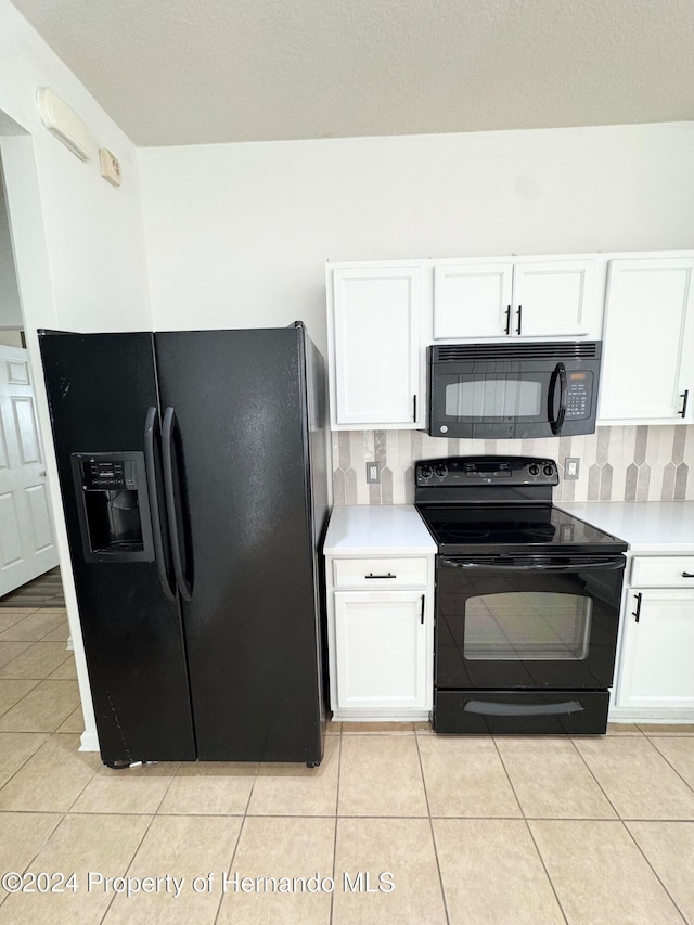 kitchen featuring decorative backsplash, light tile patterned floors, white cabinets, and black appliances