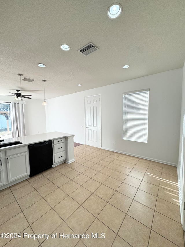 kitchen featuring pendant lighting, dishwasher, white cabinets, sink, and light tile patterned flooring