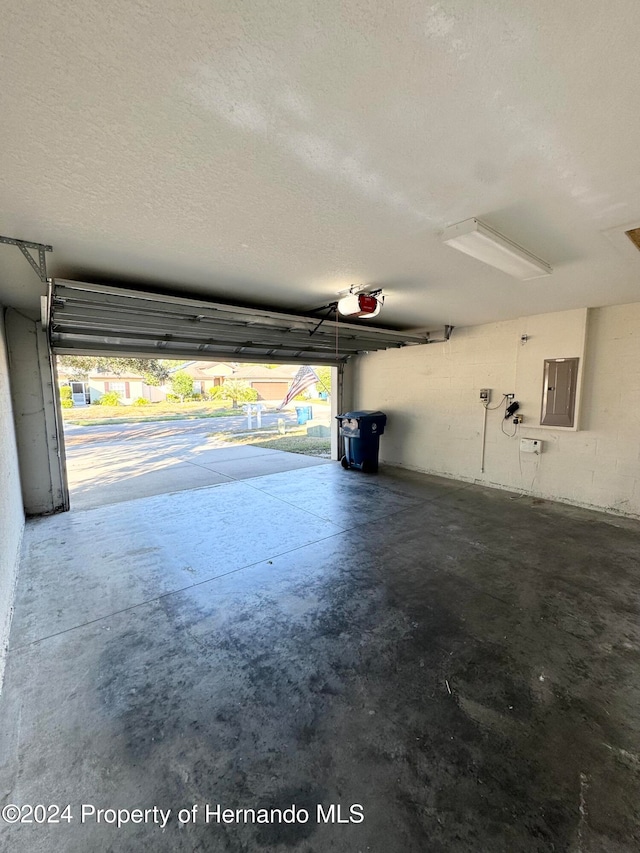 garage featuring electric panel and a garage door opener