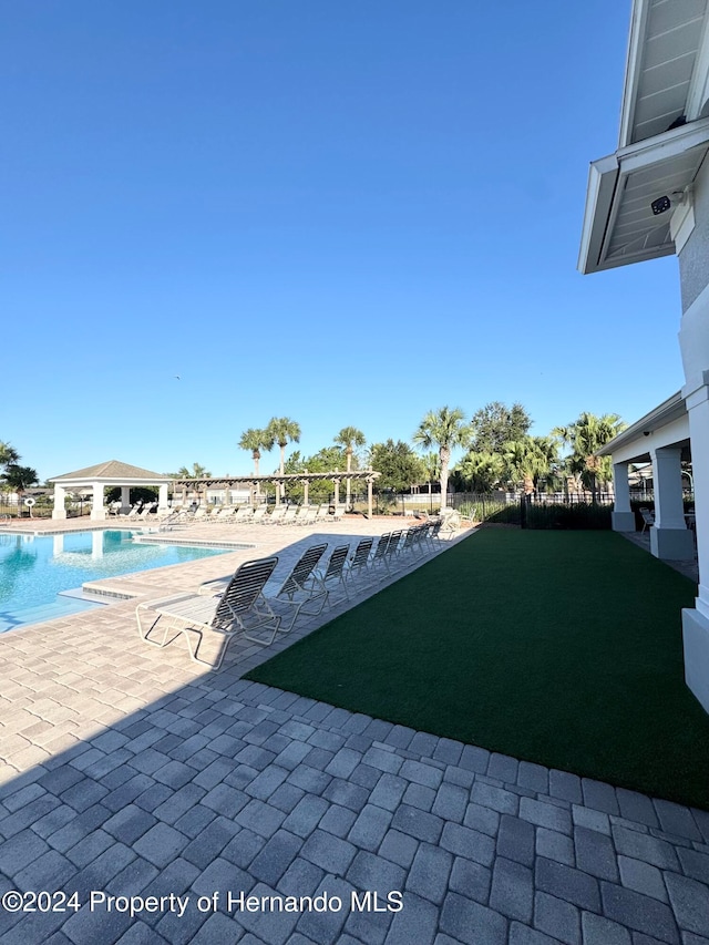 view of swimming pool with a patio area and a yard