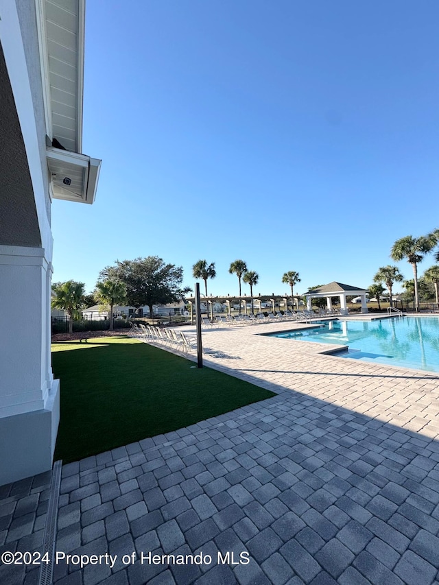 view of swimming pool featuring a lawn and a patio