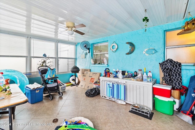 game room with tile patterned floors and ceiling fan