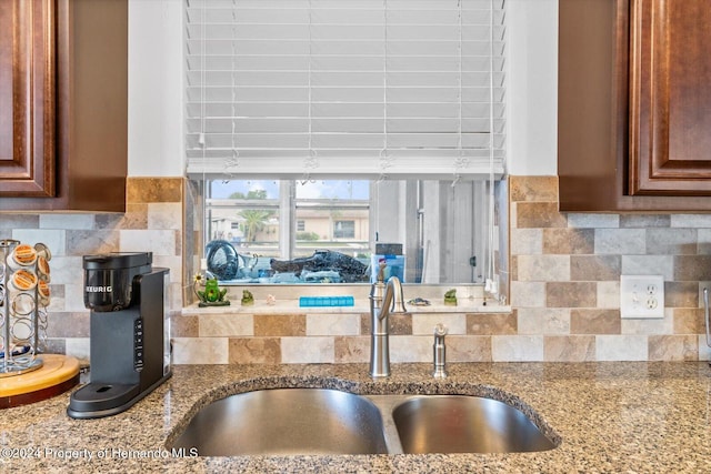 kitchen featuring decorative backsplash, light stone counters, and sink