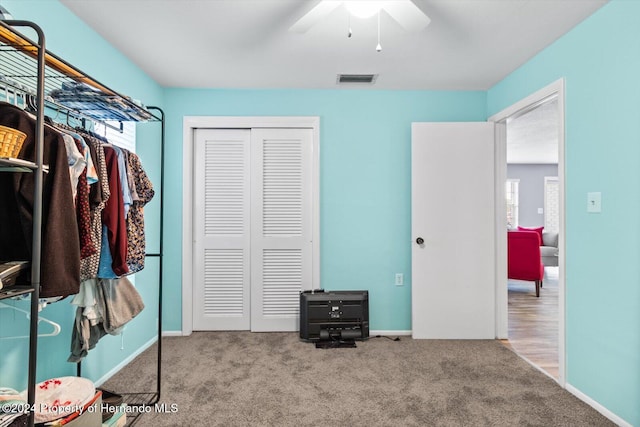 interior space featuring a closet, ceiling fan, and light colored carpet