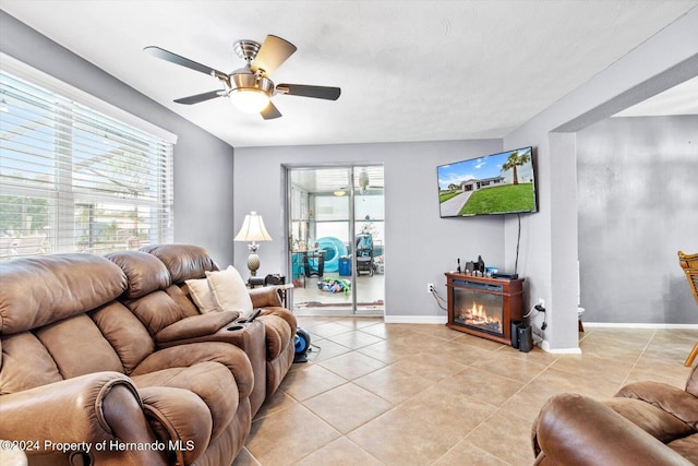 living room featuring a wealth of natural light, light tile patterned flooring, and ceiling fan