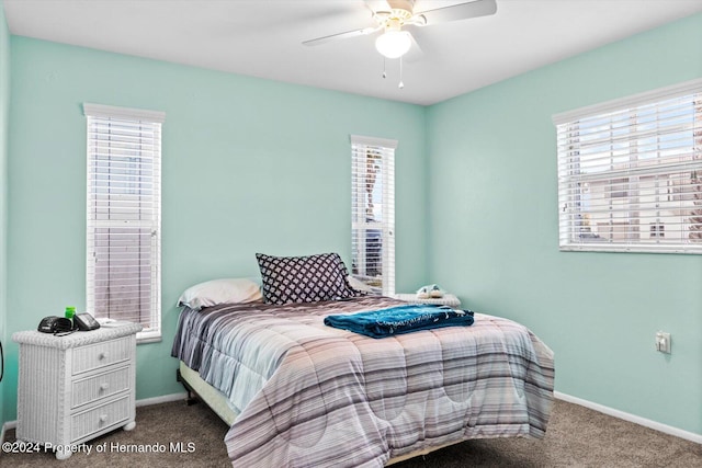 carpeted bedroom featuring multiple windows and ceiling fan