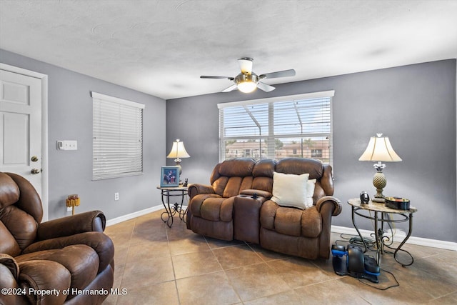 tiled living room featuring ceiling fan and a textured ceiling