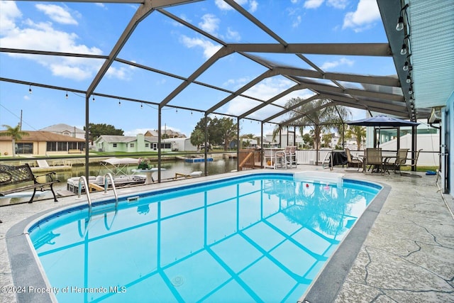 view of pool featuring a patio, a water view, and a lanai