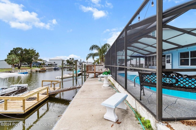 dock area with a lanai and a water view