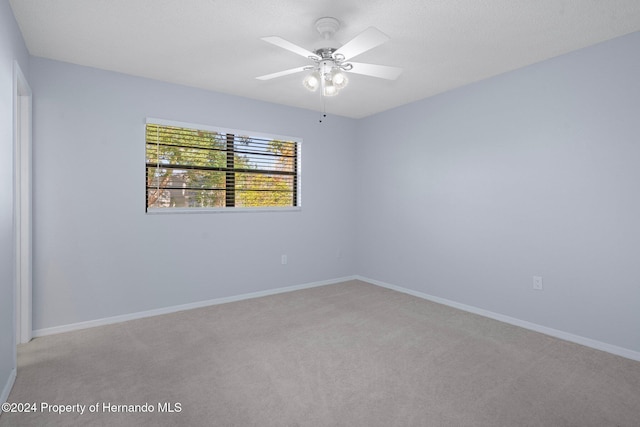 spare room with light colored carpet and ceiling fan