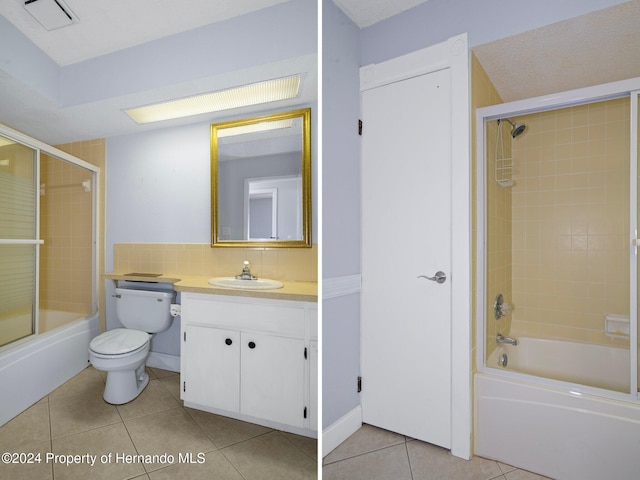 full bathroom with tile patterned flooring, a textured ceiling, vanity, and tiled shower / bath