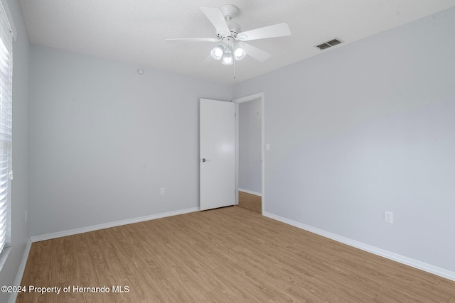 spare room with light hardwood / wood-style flooring, ceiling fan, and plenty of natural light