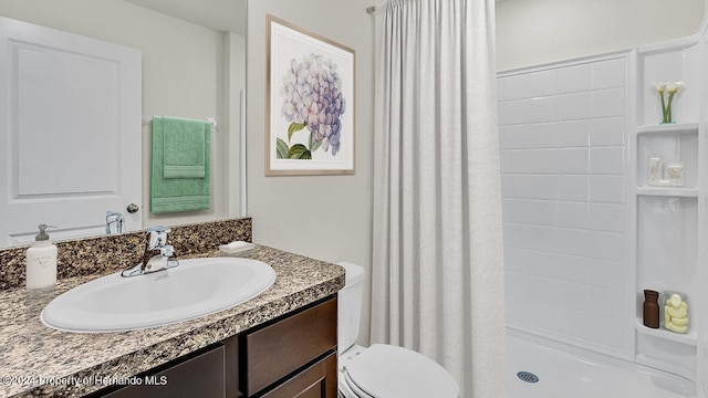 bathroom featuring toilet, vanity, and a shower with shower curtain