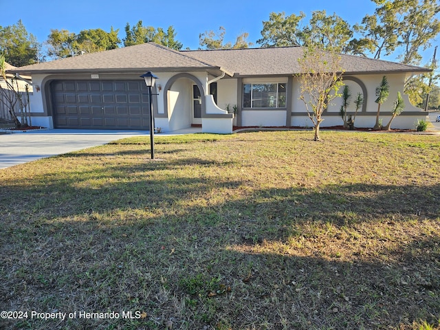 single story home featuring a garage and a front yard