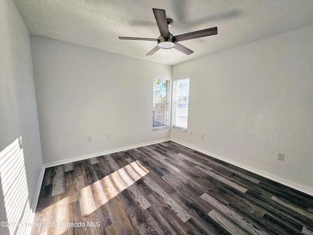 spare room featuring dark hardwood / wood-style floors, ceiling fan, and a textured ceiling