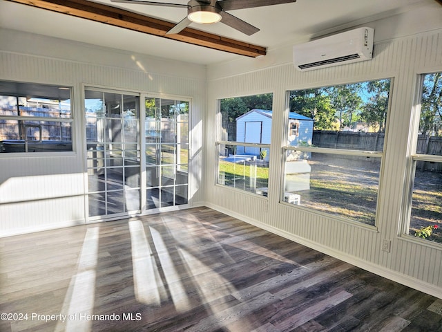 unfurnished sunroom with beam ceiling, a wall unit AC, a wealth of natural light, and ceiling fan