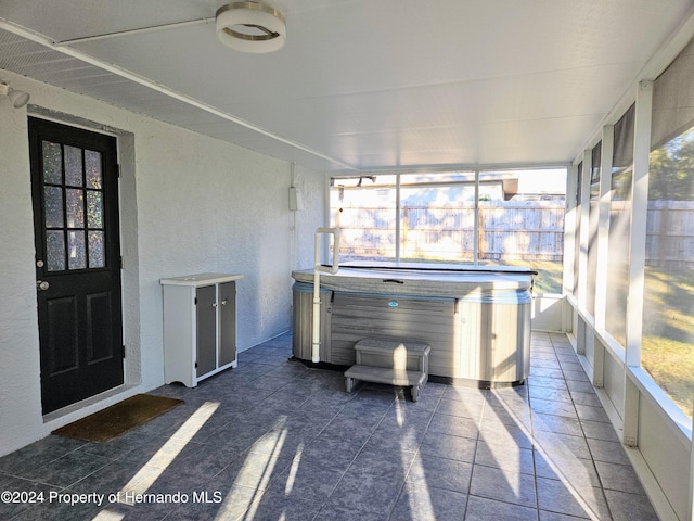 unfurnished sunroom featuring a wealth of natural light and a hot tub