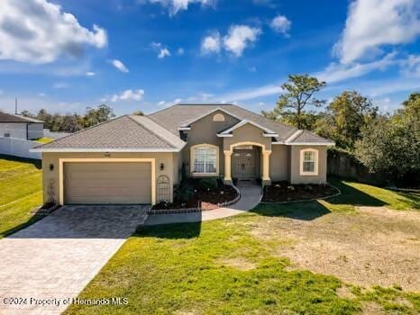 ranch-style home featuring a front yard and a garage