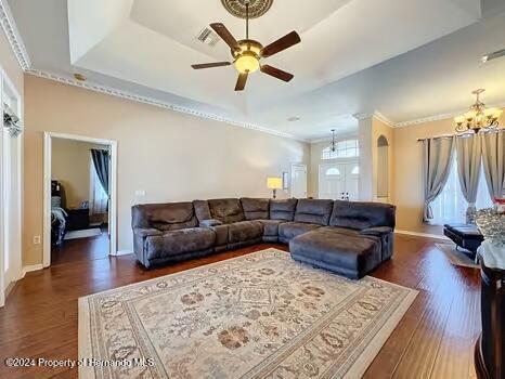 living room with dark hardwood / wood-style floors, ceiling fan, crown molding, and a wealth of natural light