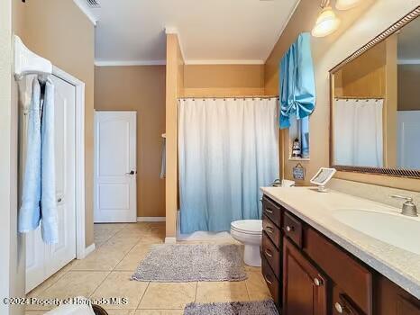 bathroom featuring tile patterned flooring, vanity, toilet, and crown molding