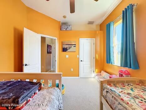 bedroom featuring ceiling fan and carpet