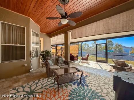 sunroom featuring ceiling fan and wooden ceiling