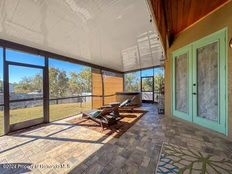 unfurnished sunroom with lofted ceiling and french doors