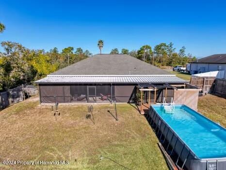 view of pool with a yard and a sunroom