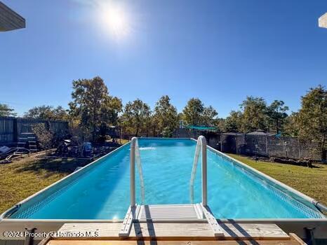 view of swimming pool featuring a lawn