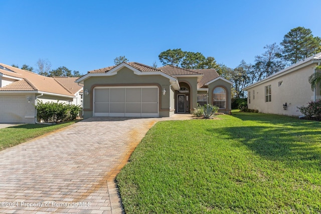 mediterranean / spanish house with a front yard and a garage