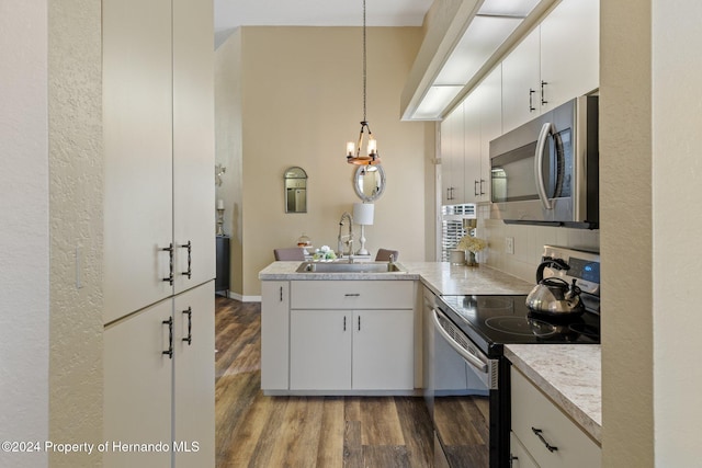 kitchen featuring white cabinetry, hanging light fixtures, stainless steel appliances, and sink